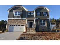 Two-story home with gray siding, stone accents, and a white garage door at 90 Bold Dr, Youngsville, NC 27596