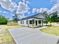 Charming single-story home featuring a concrete driveway, covered front porch, and manicured lawn at 247 Jenkins St, Erwin, NC 28334