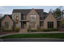 Striking two-story brick home featuring a manicured lawn, refined landscaping, and a welcoming front entrance at 4905 Foxridge Dr, Raleigh, NC 27614