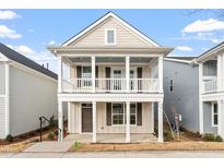 Charming two-story home featuring a double stacked porch, neutral siding, and white trim at 9237 Kitchin Farms Way # 429, Wake Forest, NC 27587
