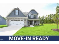 Move-in ready two-story home with gray siding, stone accents, and a two-car garage at 236 Abingdon Farms Dr, Selma, NC 27576