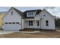 Charming white two-story home featuring an attached garage and a welcoming front porch at 2316 Eagle Shot Ct # 21, Fuquay Varina, NC 27526