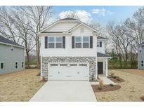 Charming two-story home with a gray stone and white facade, a two-car garage, and a concrete driveway at 254 New Twin Branch Ct, Smithfield, NC 27577