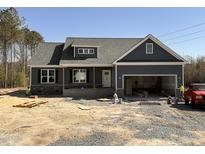 New home with gray siding, stone accents, covered porch, and an attached two-car garage at 182 Wilderness Trl, Smithfield, NC 27577
