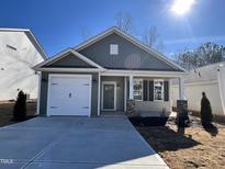 Charming single-story home featuring an attached garage and inviting front porch, offering comfort and curb appeal at 23 S Mistflower St, Clayton, NC 27520