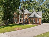 Two-story brick home with landscaped lawn and driveway at 111 N Coslett Ct, Cary, NC 27513