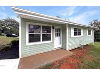 Charming exterior view of a light green house, with white trim and a well-manicured lawn at 225 W Orange St, Hillsborough, NC 27278
