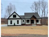 Charming single-Gathering home featuring black trim, a covered porch, and a well-manicured front yard at 2829 Faucette Ln, Burlington, NC 27217