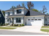 Beautiful two story home featuring professional landscaping, a large garage and grey exterior paint at 123 Cottage Way, Pittsboro, NC 27312
