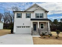 Charming two-story home featuring white siding, gray shutters, and a welcoming stone porch at 199 Grand Griffon Way, Lillington, NC 27546