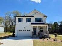 Charming two-story home with stone accents, a two-car garage, a concrete driveway and a well-manicured lawn at 199 Grand Griffon Way, Lillington, NC 27546