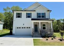 Beautiful two-story home featuring a stone facade, white siding, and a two-car garage at 199 Grand Griffon Way, Lillington, NC 27546