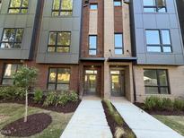 Modern townhome with a brick facade, large windows and manicured landscaping at 704 Chatham View Rd # 12, Cary, NC 27511