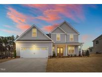 Charming two-story home with a two car garage, beautiful sunset, and manicured lawn at 1229 Brookfield Dr, Gibsonville, NC 27249