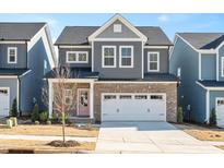 Two-story house with gray siding, brick accents, and a two-car garage at 197 Beacon Dr, Pittsboro, NC 27312