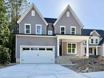 Charming two-story home with gray siding, white trim, a two-car garage, and a welcoming front porch at 2613 Silver Gate Ct, Wake Forest, NC 27587