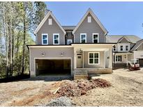 Charming two-story home with gray siding, white trim, an open garage and unfinished front yard at 2613 Silver Gate Ct, Wake Forest, NC 27587