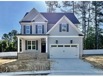 Charming two-story home with gray siding, black shutters, covered porch, and a two-car garage at 2621 Silver Gate Ct, Wake Forest, NC 27587