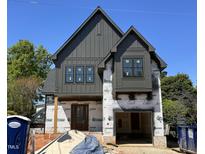 Modern home exterior with dark gray vertical siding, black window trim, and a charming gable roofline at 627 Georgetown Rd, Raleigh, NC 27608