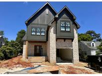 An exterior view of a two-story home featuring a brick facade, dark trim, and an attached garage at 627 Georgetown Rd, Raleigh, NC 27608