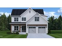 Charming two-story white brick home with attached two-car garage and a beautifully landscaped front yard at 204 E Whitaker Mill Rd, Raleigh, NC 27608