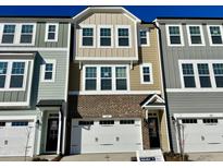 Two-story townhome with brick and siding exterior, two-car garage, and landscaping at 2103 Lambert Rd # 62, Cary, NC 27519