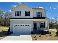 Two-story home features a white-and-gray exterior, two-car garage, and a well-manicured front yard at 235 Grand Griffon Way, Lillington, NC 27546