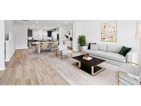 Bright living room showcasing an open floor plan, modern decor and wood-style flooring at 1170 Holding Village Way, Wake Forest, NC 27587