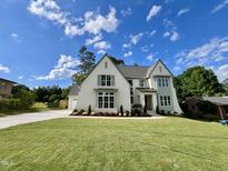 Charming new two-story home featuring a manicured lawn, lush landscaping, and elegant architectural details at 217 Dublin Rd, Raleigh, NC 27609