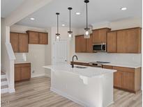 An open kitchen features wood cabinets, an island, granite countertops, recessed lights, and stainless appliances at 211 Wild Turkey Way, Lillington, NC 27546