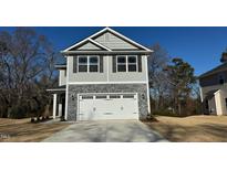 Two-story home with gray siding, stone accents, and a two-car garage at 211 Hopewell Branch Ct, Smithfield, NC 27577