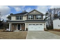 Charming two-story home with stone accents, a two-car garage, and a well-manicured lawn at 225 Hopewell Branch Ct, Smithfield, NC 27577
