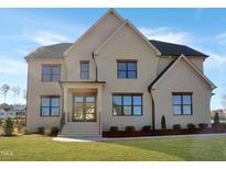 Stunning two-story home featuring a light brick exterior and dark trim on a well-manicured lawn at 2525 Silas Peak Ln, Apex, NC 27523