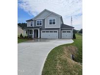 Two-story home with a two-car garage, concrete driveway, and well-manicured front lawn at 104 Gin Branch Rd, Wendell, NC 27591