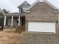 New brick home showcasing a two-car garage, covered porch and gray siding at 145 Green Haven Blvd # 83, Youngsville, NC 27596