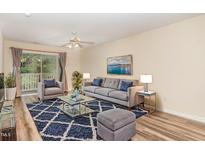 Bright living room with a comfortable sofa, stylish rug, ceiling fan, and sliding door to a balcony at 3000 Trailwood Pines Ln # 204, Raleigh, NC 27603