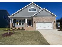 Charming single-Gathering home featuring a two-car garage, manicured lawn, and eye-catching architectural details at 1504 Maelyn Way, Fuquay Varina, NC 27526