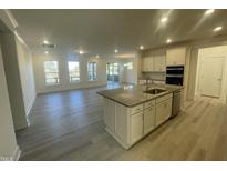 Bright, open-concept kitchen features a granite island, stainless steel appliances, and ample natural light at 1504 Maelyn Way, Fuquay Varina, NC 27526