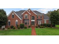 Beautiful two-story brick home featuring a manicured lawn and classic architectural design at 4600 Scottland Dr, Mebane, NC 27302