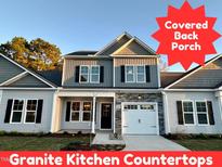Two-story house with gray siding, stone accents, and a covered porch at 215 Britt St, Smithfield, NC 27577