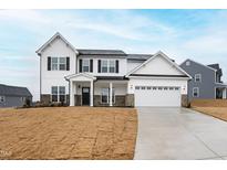 Two-story home featuring white siding, black shutters, brick accents and a two car garage at 490 Oak Park Blvd, Youngsville, NC 27596