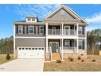 Charming two-story home with a covered porch, attached garage, and neutral color palette at 80 Bold Dr, Youngsville, NC 27596