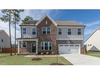 Beautiful two-story home featuring brick and gray siding, a two-car garage, and manicured front lawn at 1237 Jasmine View Way, Knightdale, NC 27545