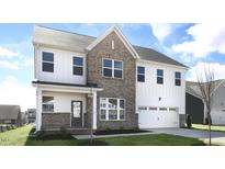 New two story construction featuring brick and light siding with an attached two car garage at 512 Lemon Daisy Ln, Knightdale, NC 27545