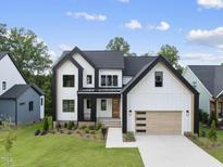New construction home with modern farmhouse design, detailed trim, manicured lawn and wood garage door at 205 Red Cardinal Ct, Youngsville, NC 27596