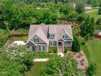 Aerial view of a two-story house with landscaped yard and large trees at 6720 Fawn Hoof Trl, Holly Springs, NC 27540