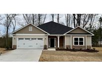 Charming single-story home with a two-car garage, neutral siding, stone accents, and a well-manicured lawn at 55 Capeside Ct, Lillington, NC 27546