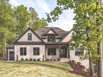 Charming two-story home featuring a stone facade, manicured lawn, and professionally landscaped accents at 144 W Beech Slope Ct, Chapel Hill, NC 27517