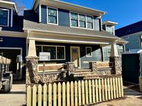 Craftsman style home with a gray exterior, stone accents, and a white picket fence at 417 E Moore St, Apex, NC 27502