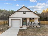 Charming home featuring a cozy front porch, white siding, and well-manicured lawn at 1101 Ridge Rd, Roxboro, NC 27573